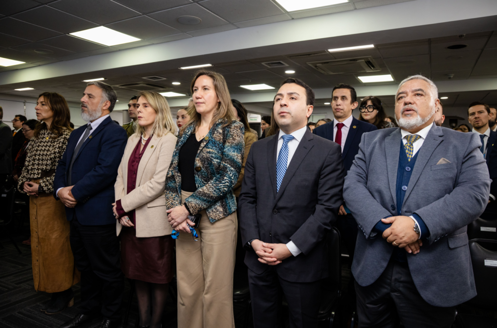 Captura-de-pantalla-2026-05-18-144716 - Instituto Profesional San Sebastián Group of professionally dressed people standing in a conference room, facing forward as if attending a formal ceremony or presentation.
