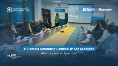 Reunión formal en una sala de conferencias con participantes sentados alrededor de una mesa larga, presentación en pantalla y logotipos de instituciones visibles (San Sebastián, El Sur).