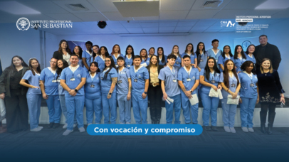 Group of healthcare students in blue scrubs posing for a class photo in a facility, with logos at the top left and the banner 'Con vocación y compromiso' at the bottom.